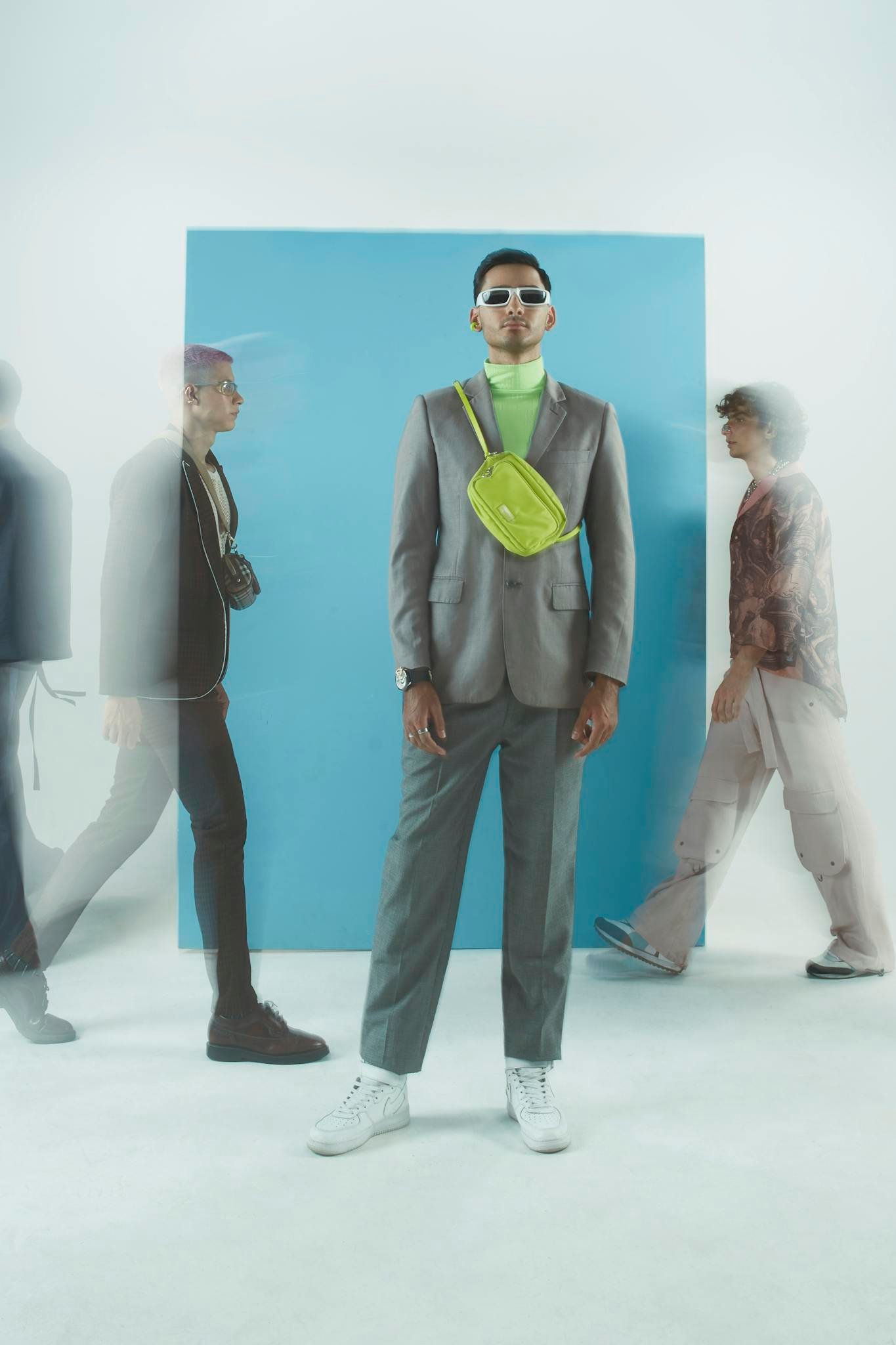 A group of stylish young adults showcases modern fashion trends against a vibrant blue backdrop.